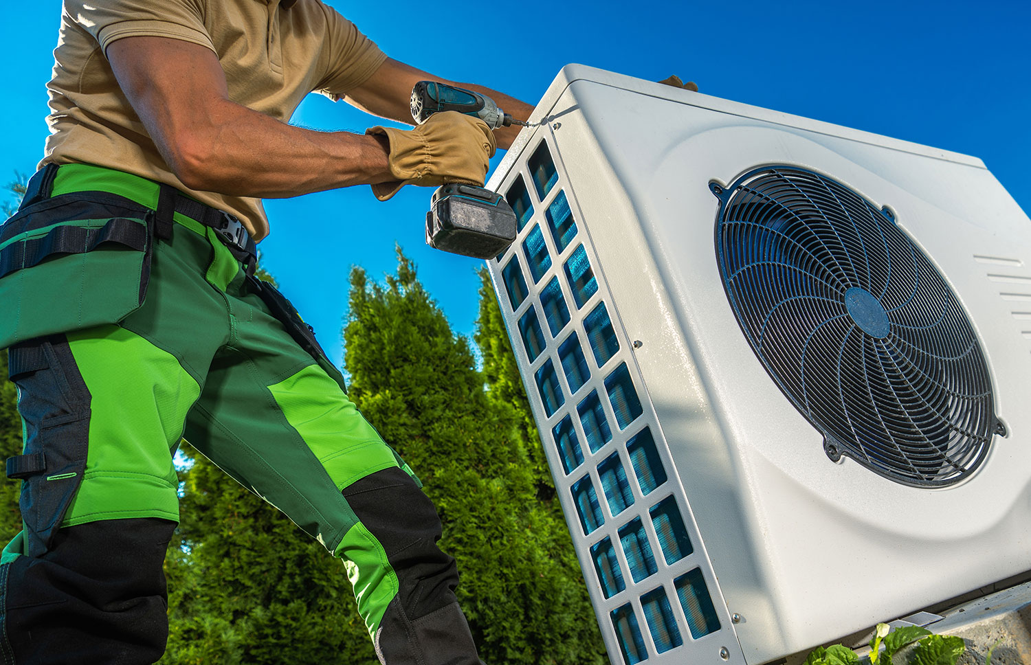 An image of guy installing an air source heat pump.