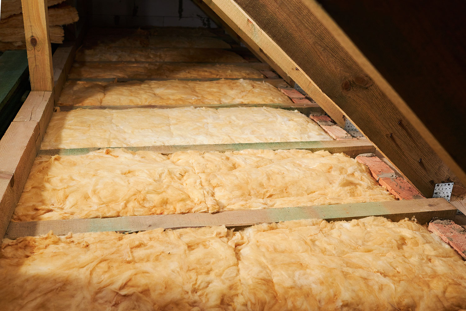 An image of guy installing loft insulation.