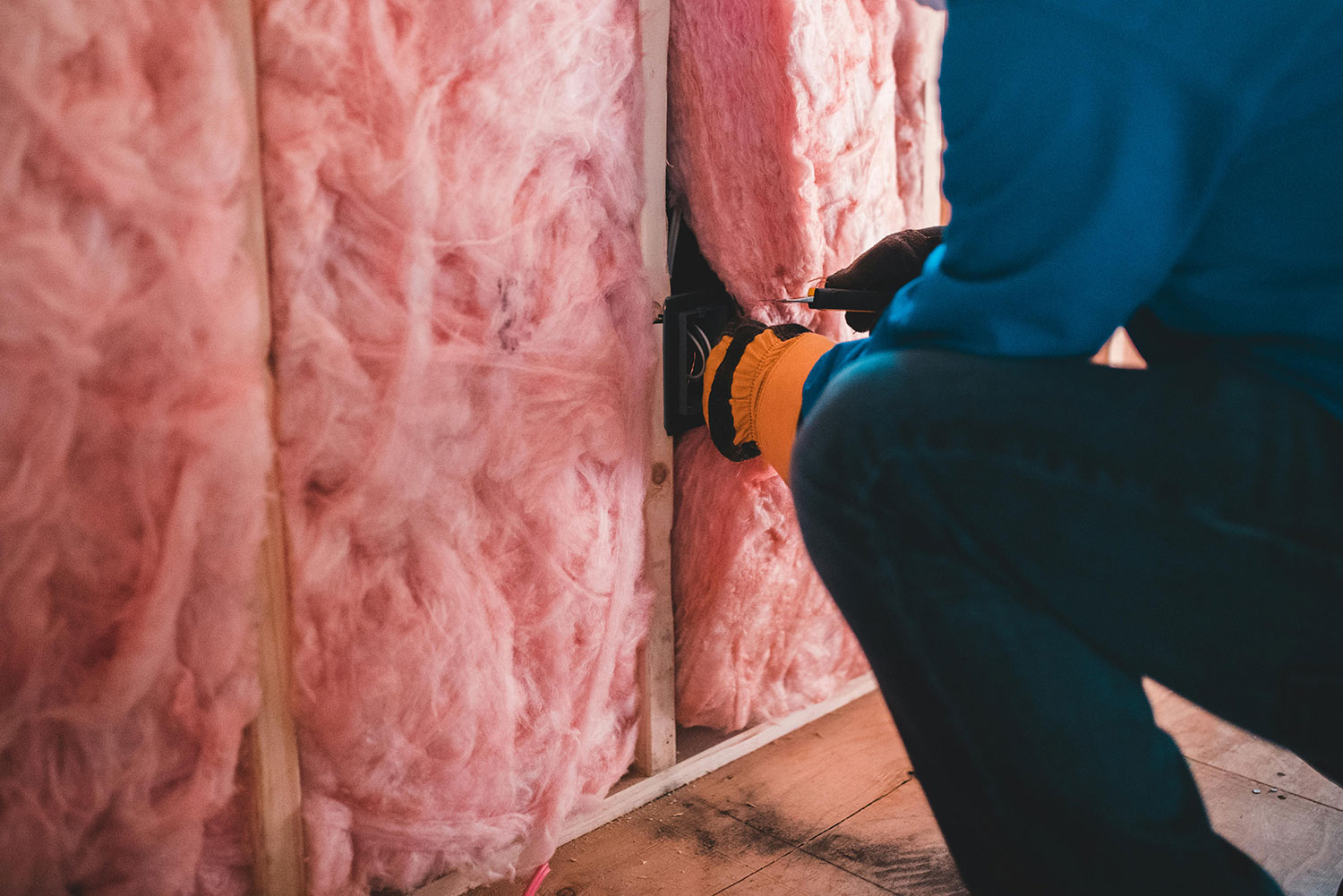An image of guy installing wall insulation.